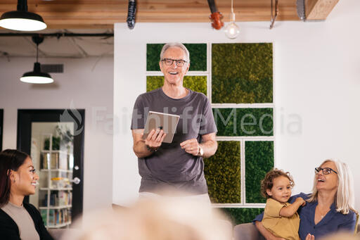 Man Holding an iPad and Leading Small Group