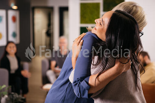 Two Women Hugging at Small Group