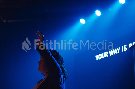 Worship Leader Raising Hand on Stage