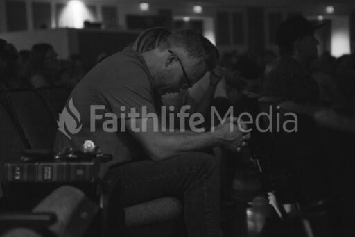 Man Bowing Head in Prayer During Church Service