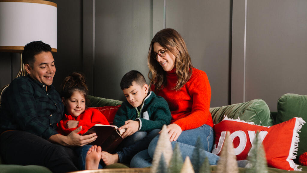 Young Family Reading the Bible Together at Christmastime large preview