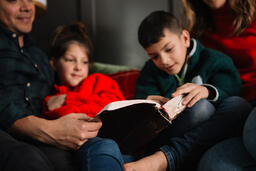 Young Family Reading the Bible Together at Christmastime  image 3