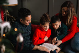 Young Family Reading the Bible Together at Christmastime  image 2