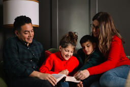 Young Family Reading the Bible Together at Christmastime  image 4
