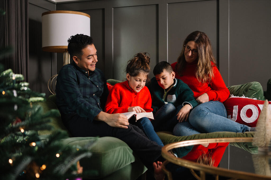 Young Family Reading the Bible Together at Christmastime large preview