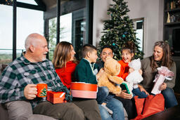 Multi-Generational Family Opening Presents in Front of the Christmas Tree  image 1