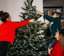 Mother and Children Decorating the Christmas Tree Together  image 3
