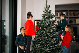 Mother and Children Decorating the Christmas Tree Together  image 1