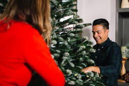Young Married Couple Decorating a Christmas Tree Together  image 5