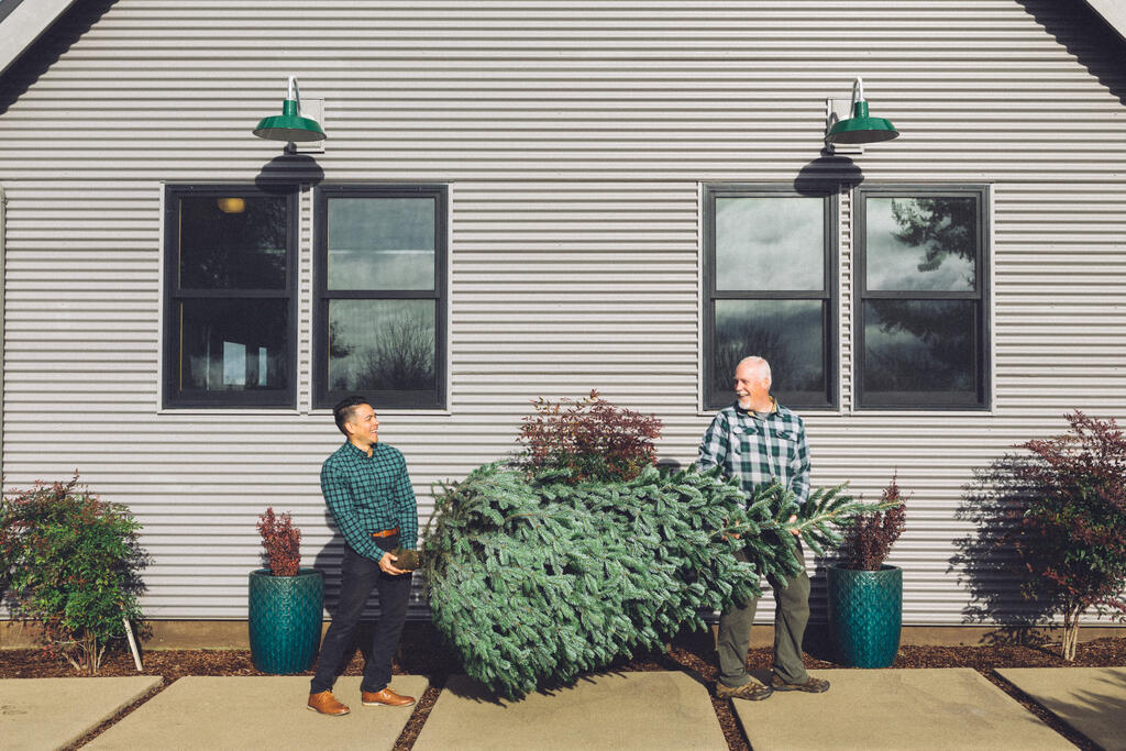 Two Men Carrying a Christmas Tree into a House large preview