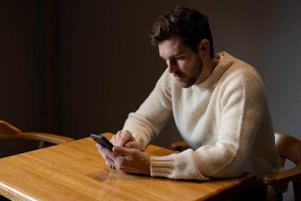 Man Scrolling on His Phone Alone large preview