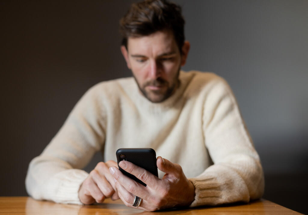 Man Scrolling on His Phone Alone large preview