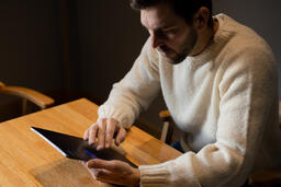 Man Reading on an iPad Alone  image 4