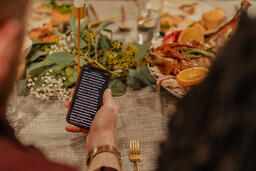 Man Reading from the Bible on His Phone before Thanksgiving Dinner  image 1