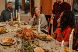 Friends Laughing and Enjoying Thanksgiving Dinner Together  image 1