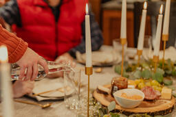 Man Pouring Water for People at the Dining Table  image 3