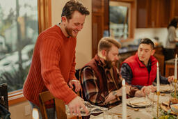 Man Pouring Water for People at the Dining Table  image 1