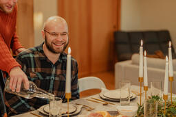 Man Pouring Water for People at the Dining Table  image 4