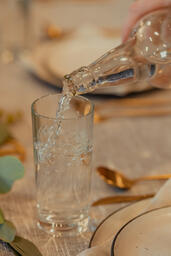 Man Pouring Water into Glasses at Thanksgiving Table  image 2