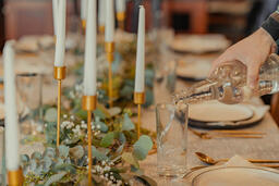 Man Pouring Water into Glasses at Thanksgiving Table  image 4