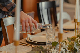 Man Pouring Water into Glasses at Thanksgiving Table  image 5