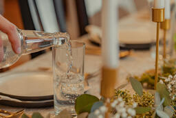 Man Pouring Water into Glasses at Thanksgiving Table  image 3