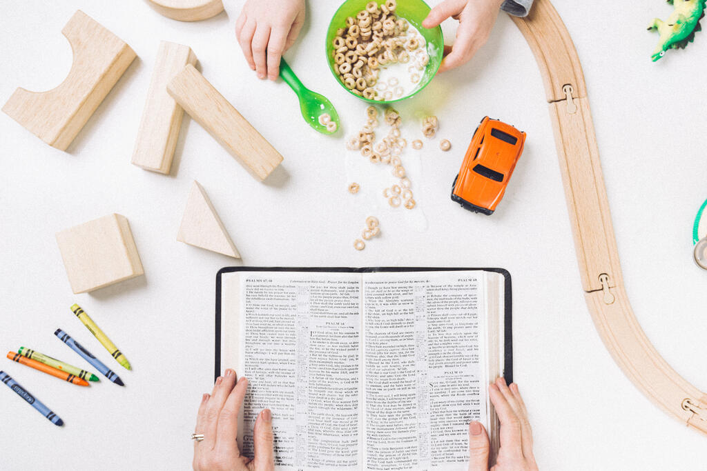Mom Reading the Bible While Her Child Spills His Cereal large preview