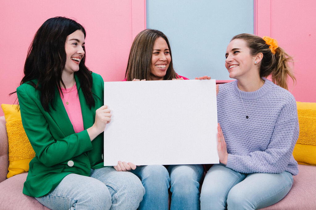 Women Holding a Blank Poster and Smiling large preview
