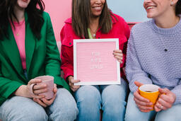 Women Holding a Pink Letter Board Reading YOU ARE LOVED  image 2