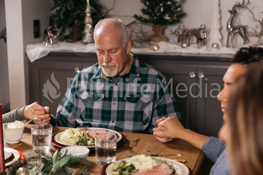 Family Praying Together Before the Christmas Meal