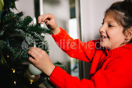 Young Girl Decorating the Christmas Tree