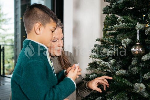 Grandmother and Grandson Decorating the Christmas Tree Together