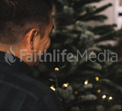 Man Putting Twinkle Lights on a Christmas Tree