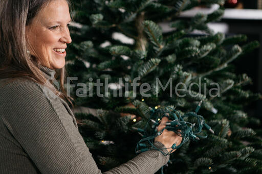 Woman with Gray Hair Decorating a Christmas Tree