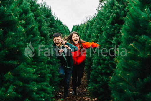 Young Kids Running through a Christmas Tree Farm