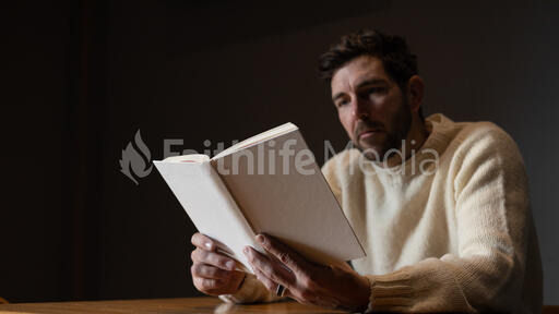 Man Reading a White Blank Book