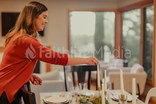 Woman Lighting Candles at the Thanksgiving Table