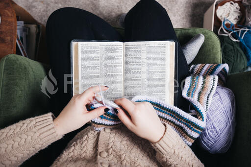 Woman Reading the Bible While Crocheting