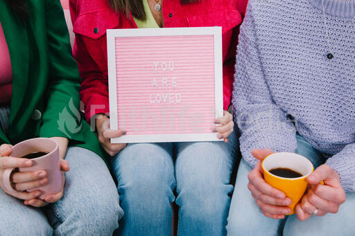Women Holding a Pink Letter Board Reading YOU ARE LOVED